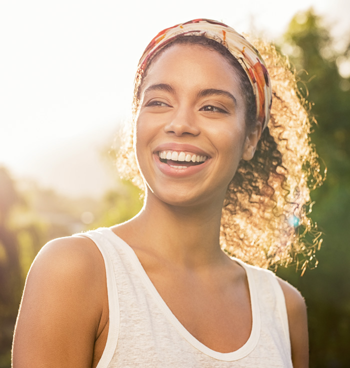 A smiling girl with hair band and curly hair